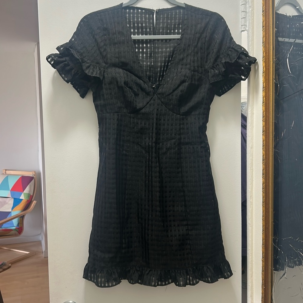 little black mini dress with ruffles on the sleeves and hem line.